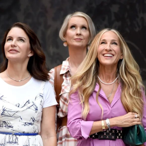 Stylized photo of Carrie, Miranda, and Charlotte walking in New York City, reimagined as empowered, modern women in their 50s